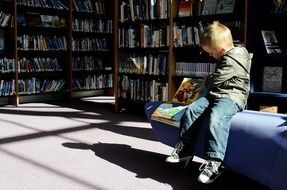 young boy sitting in library