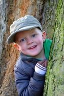 young boy posing with tree