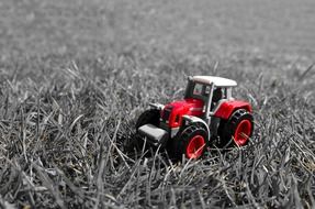 red tractor toy model grass