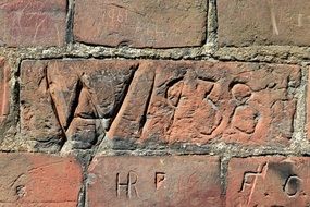 engraving on a wall red brick