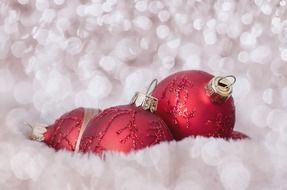 red Christmas baubles on a blurred white background