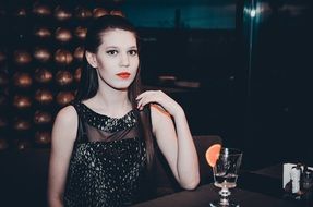 girl with long straight hair with the drink in a bar