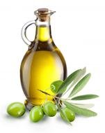 olive oil in a glass bottle next to green olives