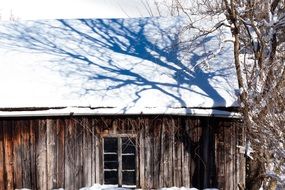 Snow on the roof of an old wooden house