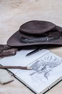 cowboy hat and drawing of an indian