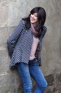 young dark-haired woman standing at the wall