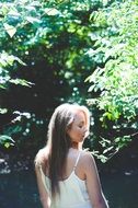 girl in the sun on the background of the forest