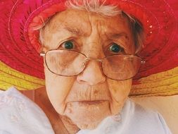 portrait of an old woman with glasses and a hat