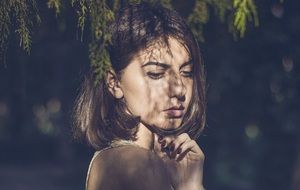 girl posing in the shade of a tree