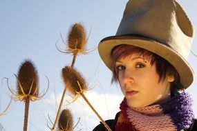 girl in a hat among meadow grass