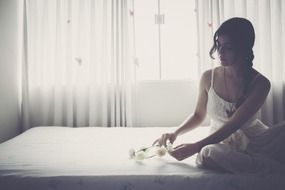 girl in a white dress sitting on the bed