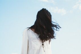 brunette woman on the blue sky background