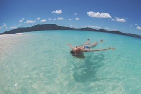 girl swims in the tropical ocean