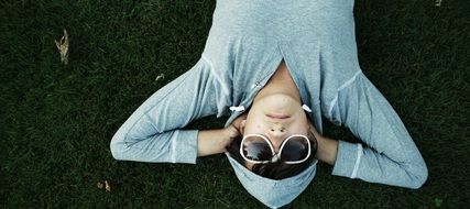 portrait of young man in a sweatshirt lying on the grass