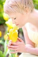 Portrait of blond girl smelling tulips