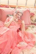 vintage woman in pink dress on the phone