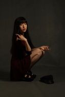 Asian model in a black dress in a photo studio