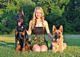 german shepherd and woman and doberman