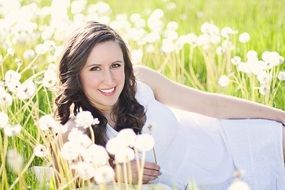 beautiful brunette on a field among dandelions