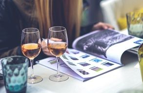 woman reading catalog near the glasses with drinks