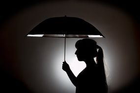 silhouette of a woman under umbrella