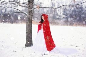 pretty happy girl near the tree in snowy winter