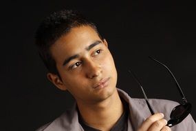 young man holding black glasses