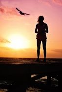 silhouette of a woman on the coast at sunset