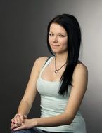 girl with black hair posing on a chair