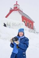 photographer woman near the lighthouse in winter season
