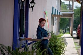 girl in a jeans suit stands near the fence