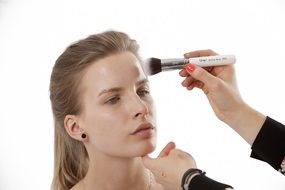 stylist with makeup brush