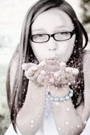 young girl pokes sparkles from a palm