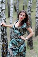 young woman posing near the tree