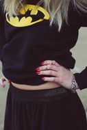 girl in a sweatshirt with batman and red manicure