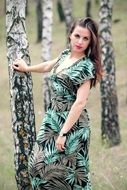 young girl posing near trees in a grove