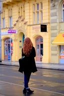 redhaired woman standing at street, czech