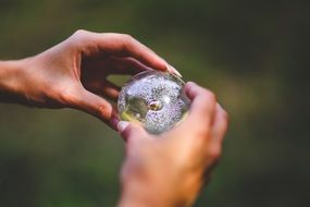 small crystal ball in hands