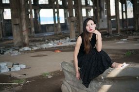 thoughtful asian model in black dress in the building