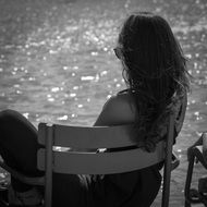 girl sitting on a chair near the sea