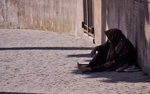 old poor woman is on a street