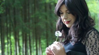 girl with a white flower in the forest