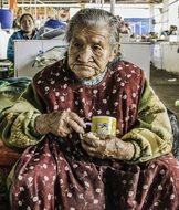 old woman with a cup of coffee in Peru