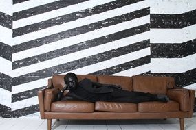 unique man in black clothe rests on sofa