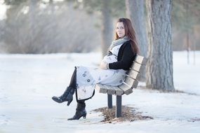 pregnant woman on a bench in winter