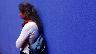 photo of a girl on a background of blue wall