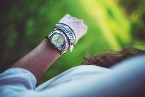 watch and silver bracelets on a female hand