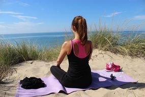 Girl doing yoga on a beach