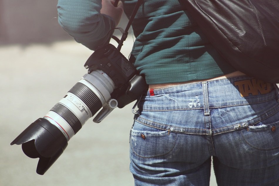 professional camera hanging on a girl’s shoulder