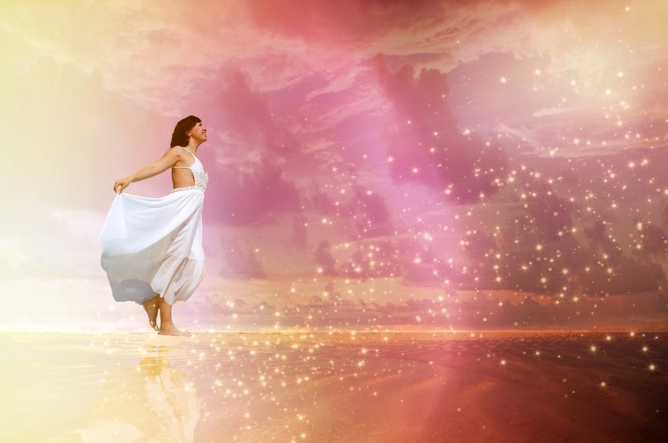 woman in a dress in the glare of light on the beach